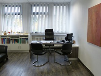 Behandlungsraum - Schreibtisch des Arztes mit Besucher-Sitzgelegenheiten